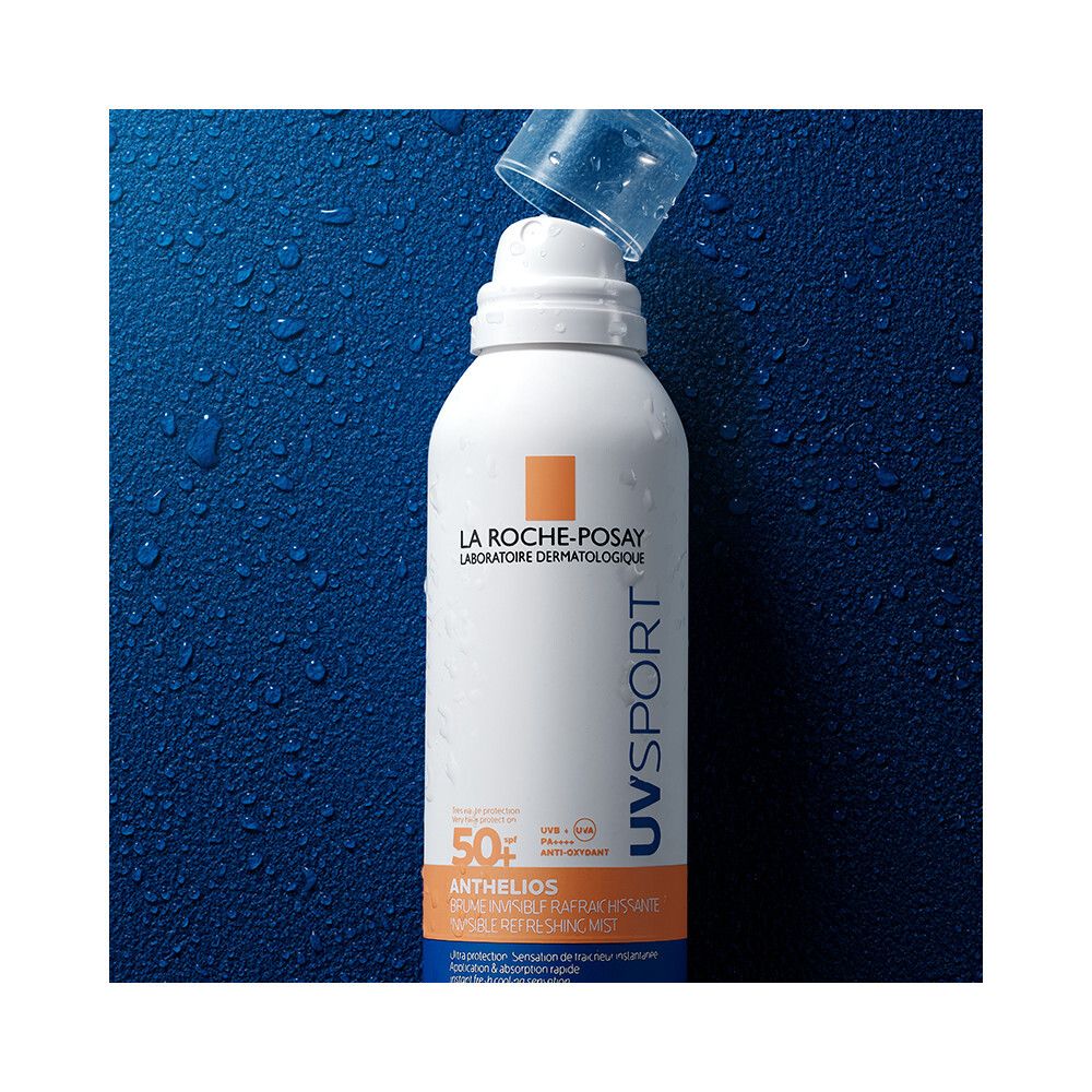 La Roche-Posay Anthelios UV Sport Brume SPF50+. Sprayfles met open dop. Blauwe achtergrond met waterdruppels.