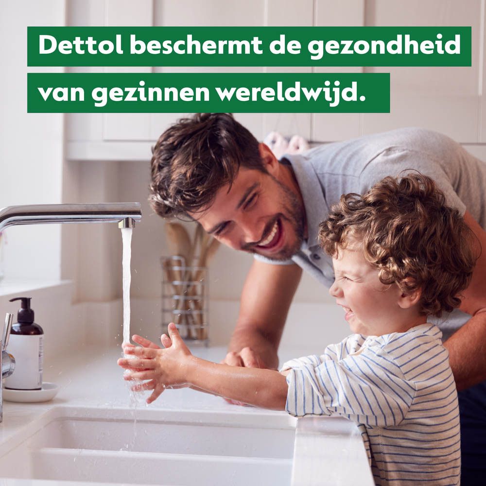 Twee groene kaffir limoenen en witte bloesems op groene achtergrond.