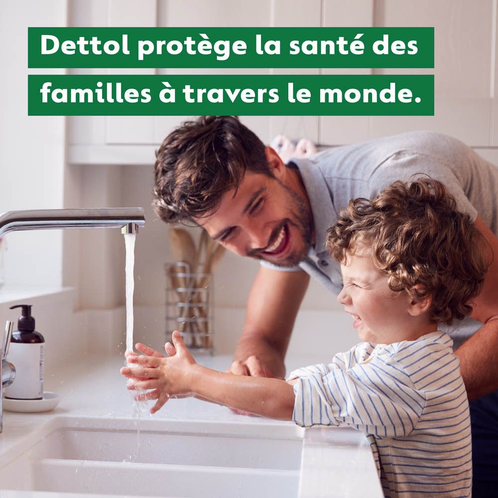 Père et fils riant en se lavant les mains dans une cuisine.