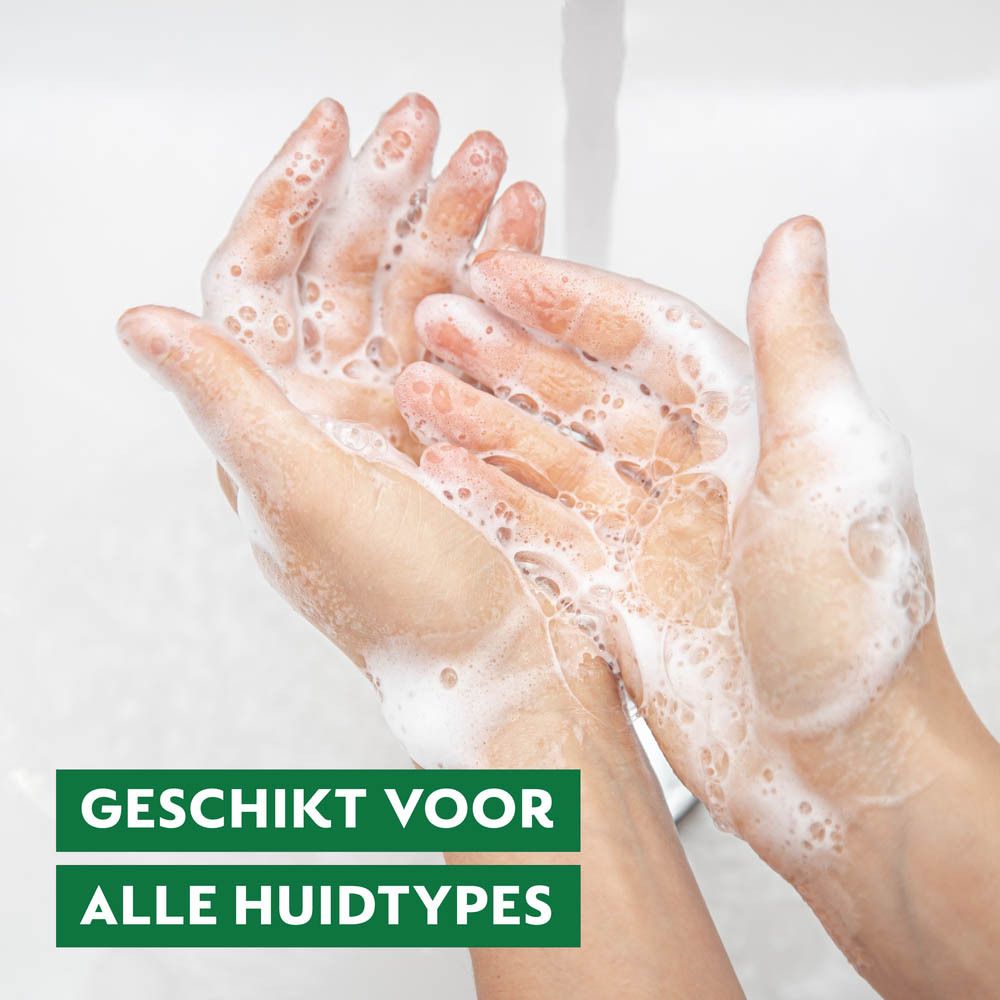 Vader en zoon lachen terwijl ze handen wassen in de keuken.