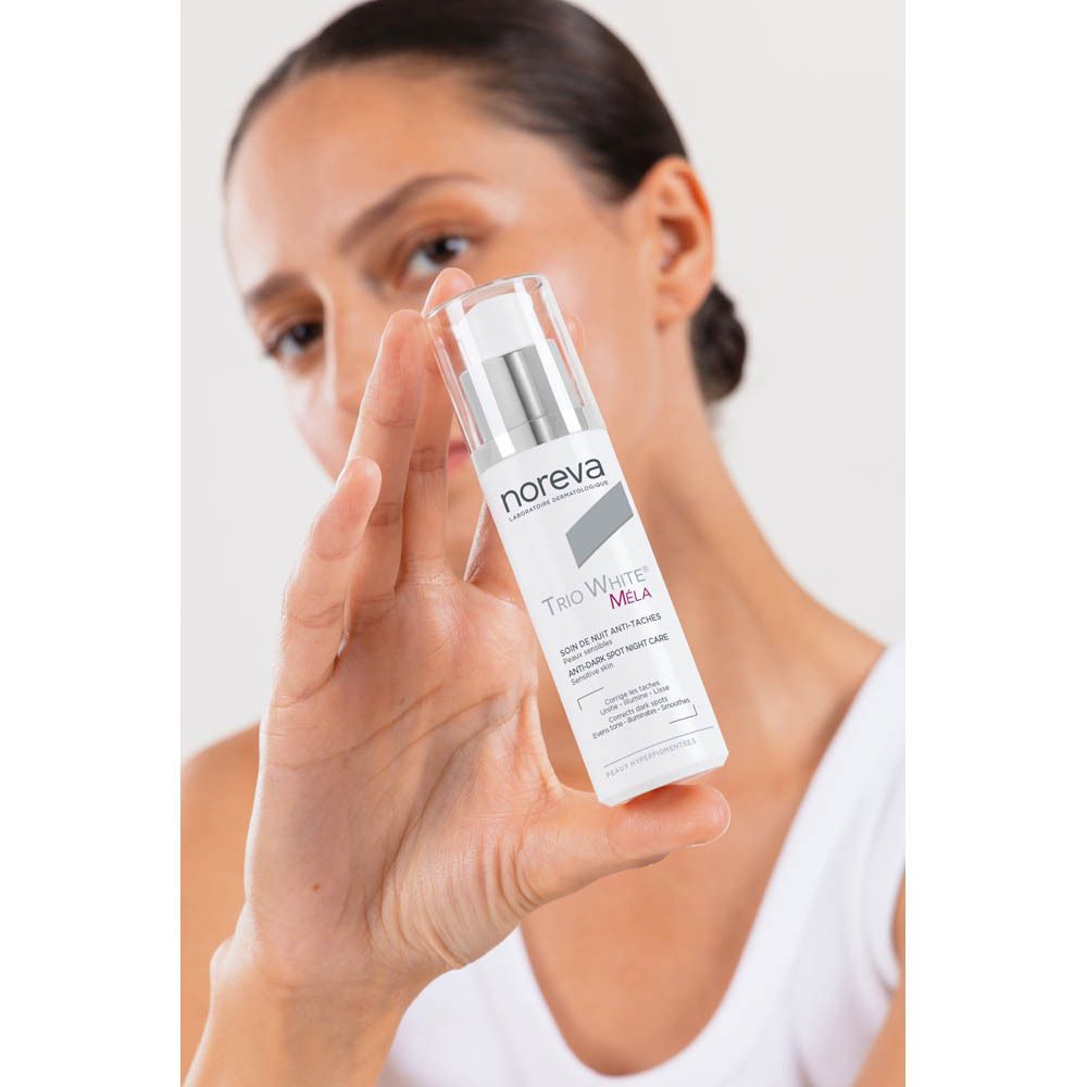Femme tenant le soin de nuit anti-taches Noreva Trio White Mela.