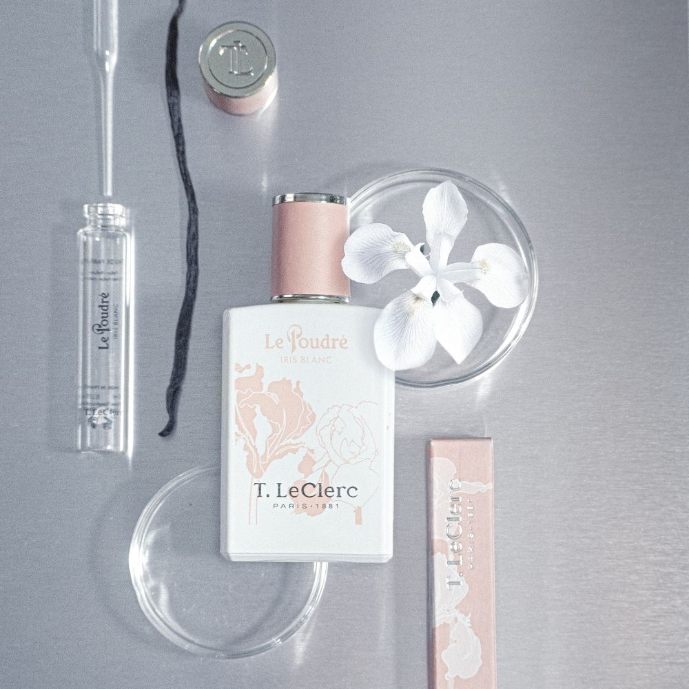 Flesje T. LeClerc Le Poudré Iris Blanc Eau de Parfum met laboratoriumbenodigdheden.