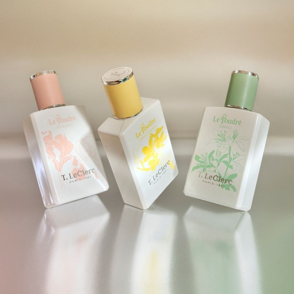 T. LeClerc Eau de Parfum Le Poudré Frangipanier fles tussen bloemen.