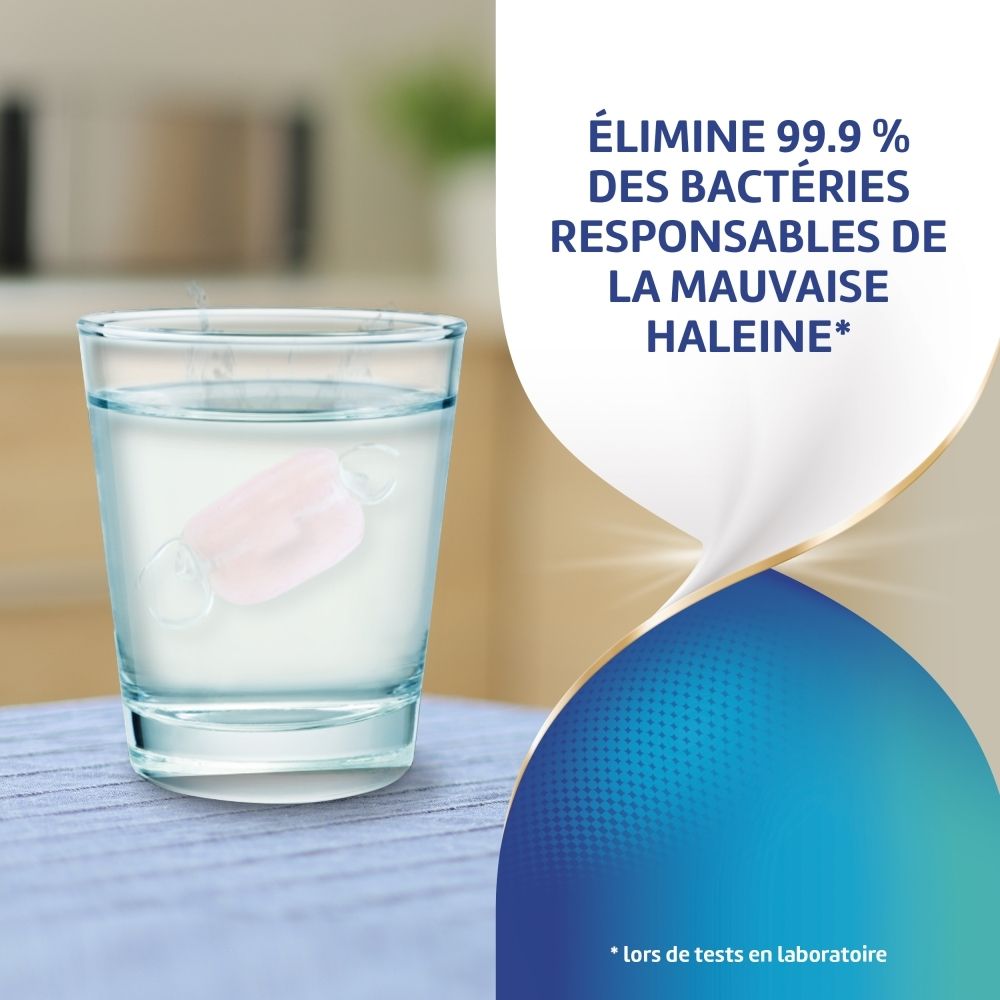 Comprimé dans un verre d'eau. Inscription: Élimine 99,9% des bactéries responsables de la mauvaise haleine.
