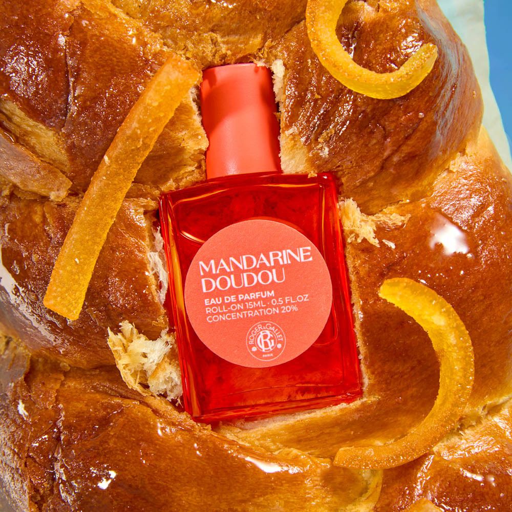 Fles op brioche. Fles: Mandarine Doudou Eau de Parfum. Oranje. Opschrift.