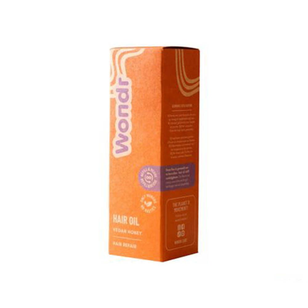 Productverpakking. Oranje doos met opschrift: Wondr, Hair Oil, Vegan Honey, Hair Repair. Met logo.