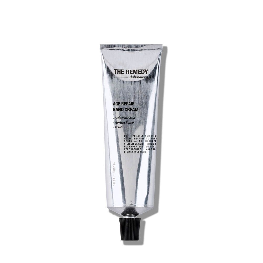 Tube argenté avec bouchon noir. Inscriptions: THE REMEDY, AGE REPAIR HAND CREAM.