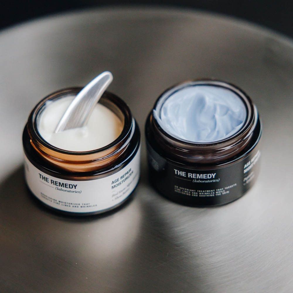 Deux pots sur une surface. Un pot avec de la crème, un avec une spatule.