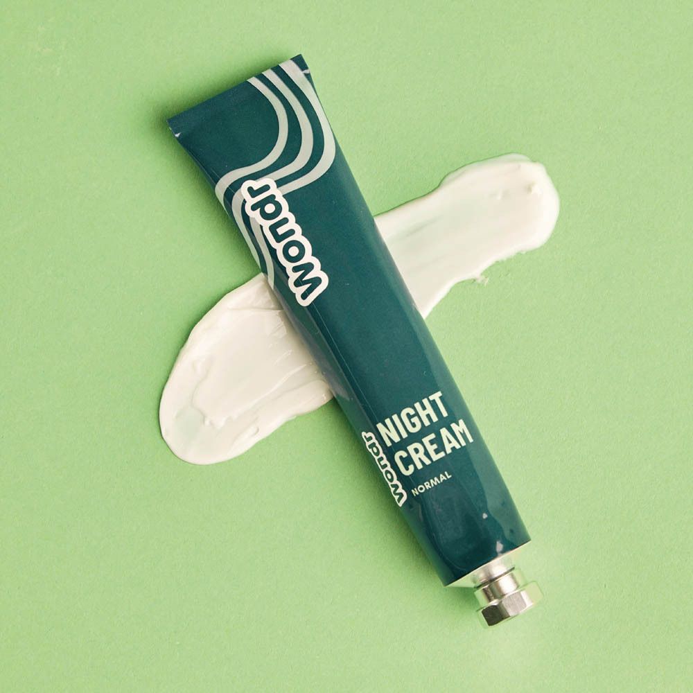 Vrouw brengt crème aan, tekst "Night Cream".