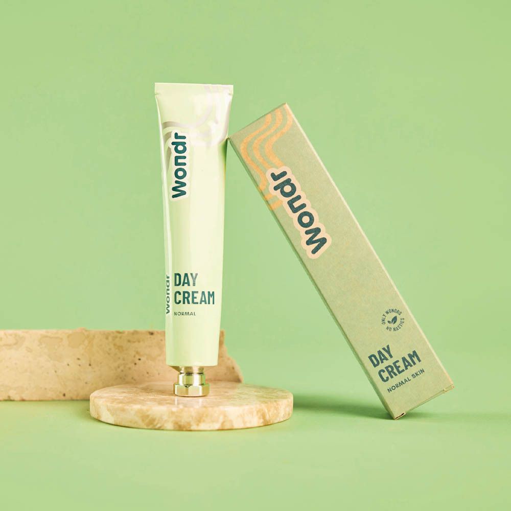 Lichtgroene tube en doos. Op steen. Tekst: Day Cream, Normal Skin.