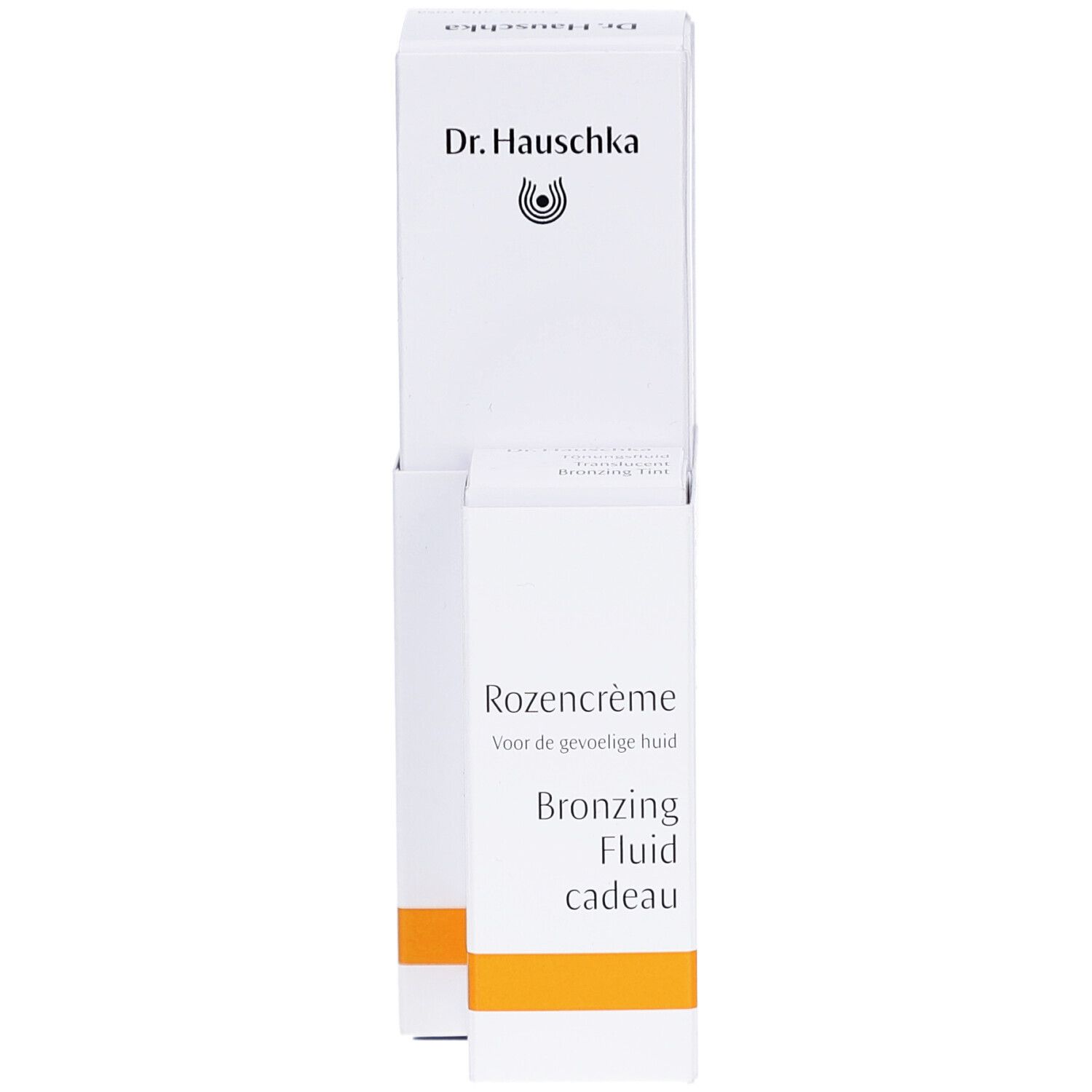 Witte verpakking met Dr. Hauschka logo. Tekst: Rozencrème, Bronzing Fluid cadeau. Oranje streep.