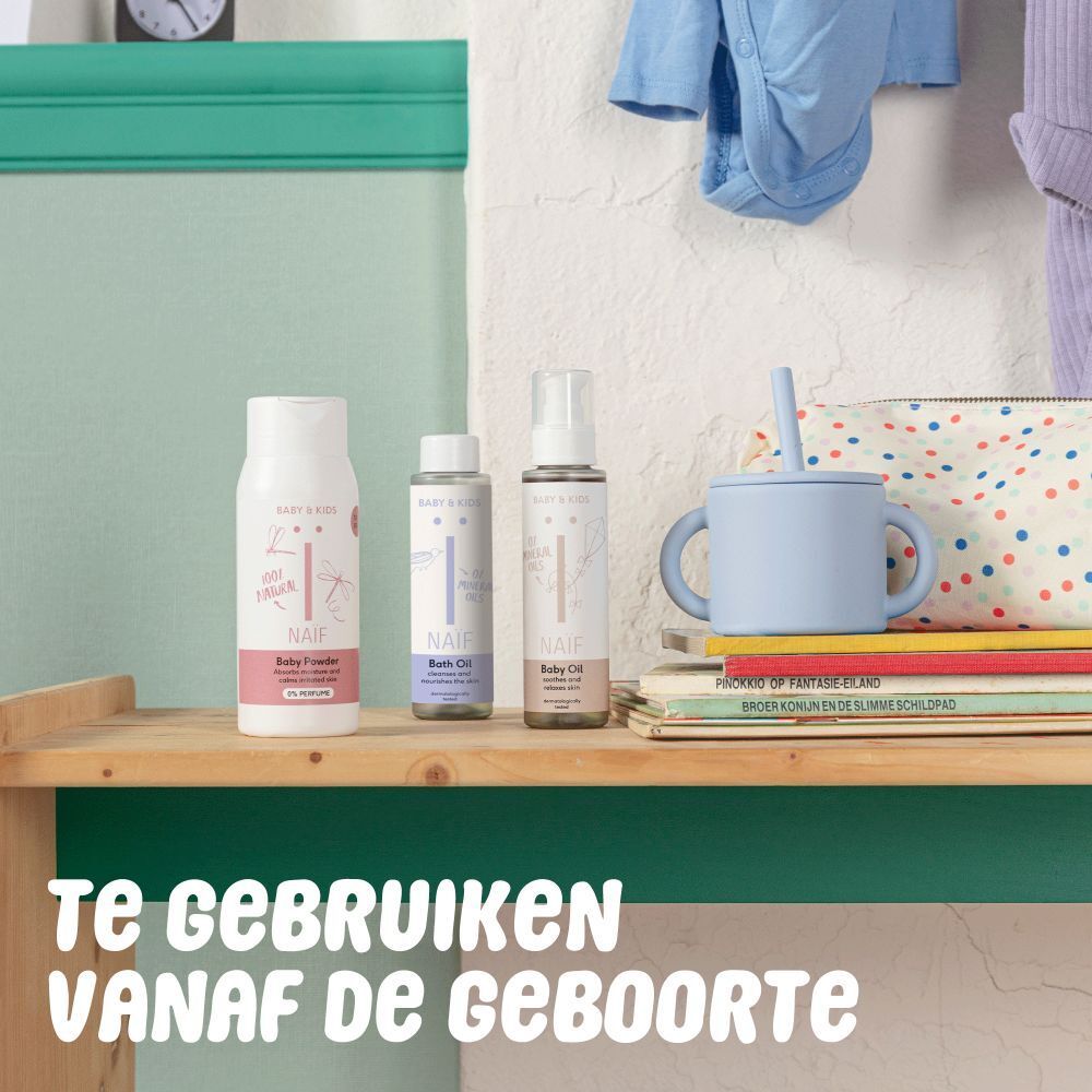 Trois produits Naïf sur une étagère. Huile de bain, huile pour bébé et spray. Texte: Te gebruiken vanaf de geboorte.