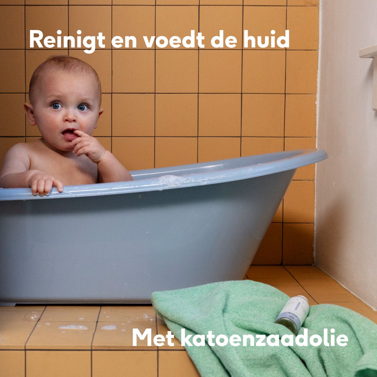 Baby in bad. Baby in badwater. Naïf badolie op de rand. Tekst: Reinigt en voedt de huid.