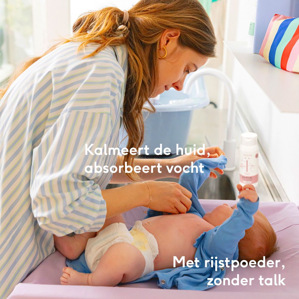 Vrouw verschoont baby. Baby op aankleedtafel. Naïf Baby Powder fles. Tekst: Kalmeert de huid, absorbeert vocht.