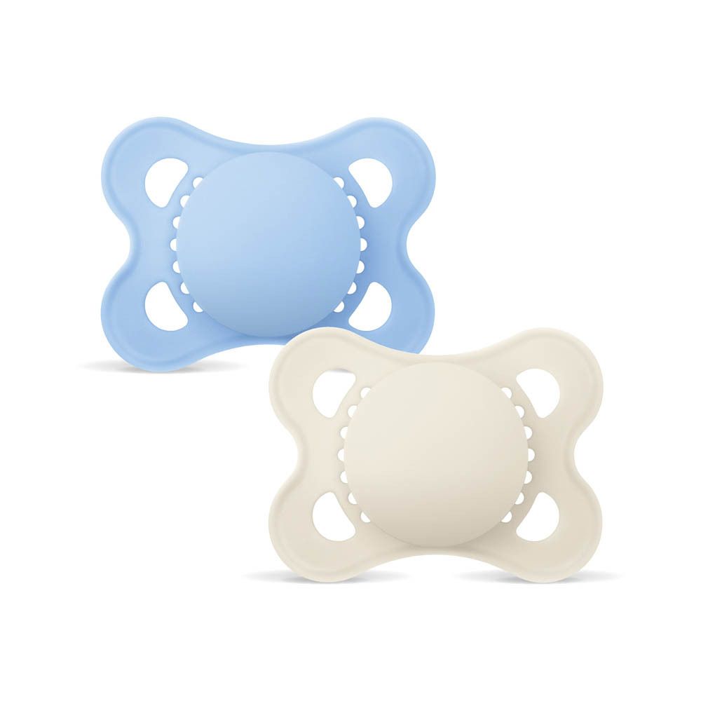 Twee MAM Original siliconen fopspeentjes (0-6 maanden) in blauw en crème, vrijstaand op witte achtergrond.