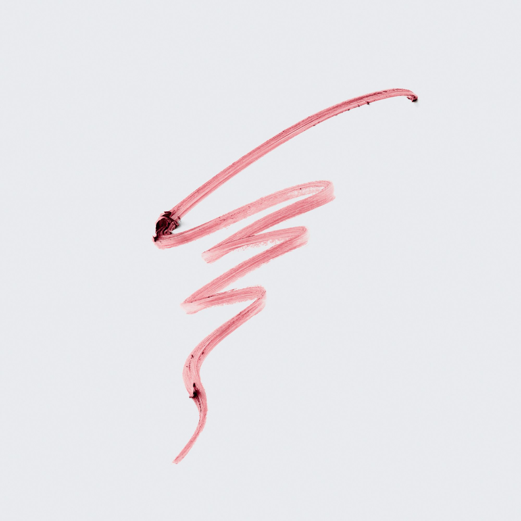 Roze lippenstiftstreep op lichte achtergrond. Textuur en kleur van het product zichtbaar.