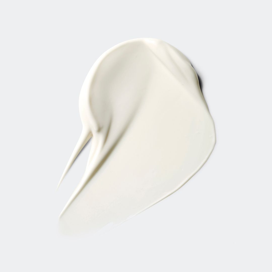 Vlek zonnecrème. Witte, romige textuur. Op lichte achtergrond.