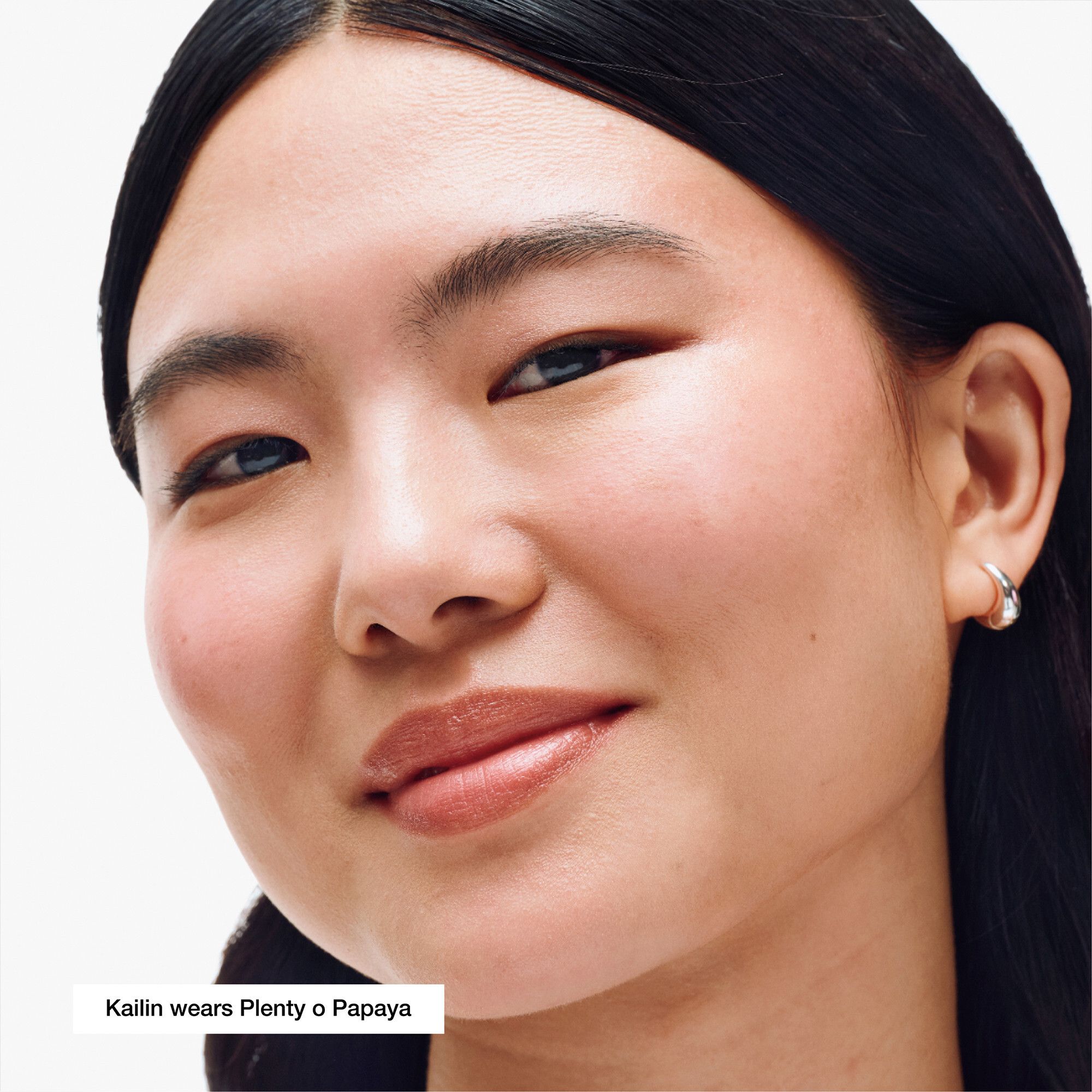 Gezicht van een vrouw met Clinique Chubby Stick™ Baume couleur joues Plenty O' Papaya. Huidtint.