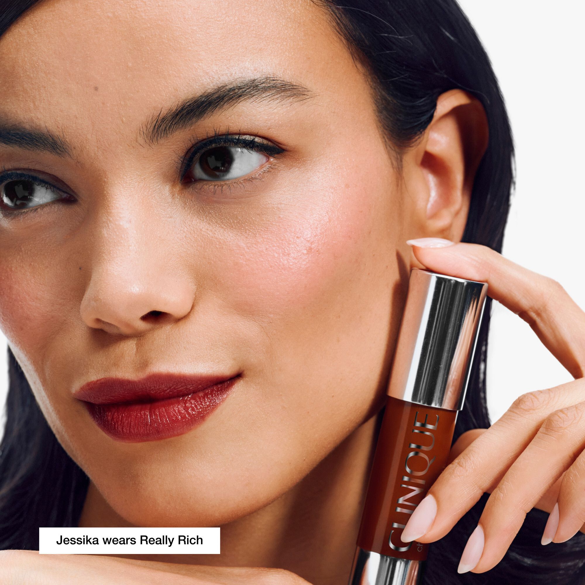 Vrouw houdt Clinique Chubby Stick vast. Kleur van lippenstift. Tekst: 'Jessika wears Really Rich'.