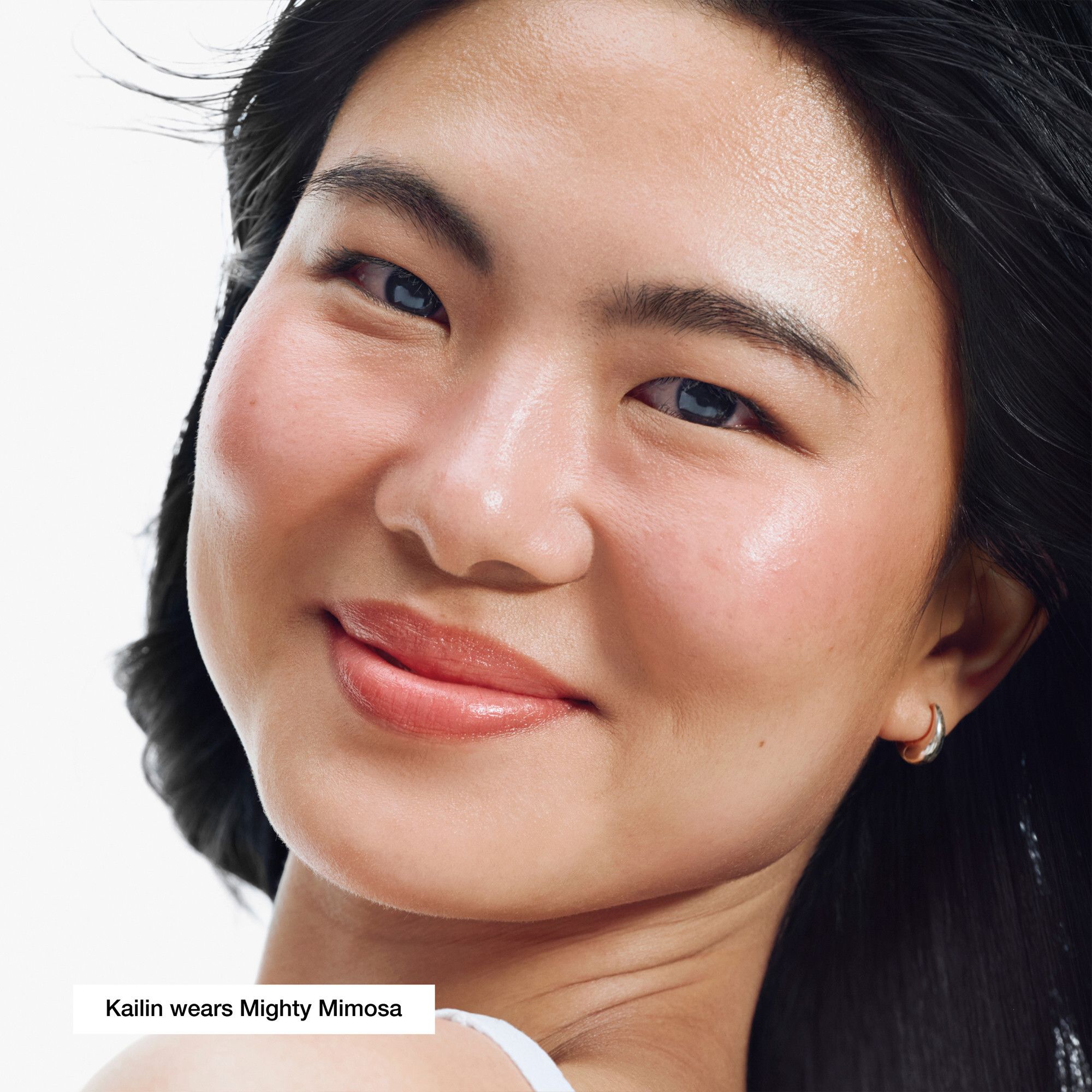 Femme portant la couleur de lèvres Mighty Mimosa. Texte: Kailin wears Mighty Mimosa.