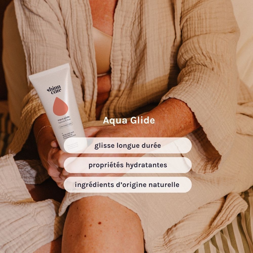 Personne tenant un tube. Texte: Aqua Glide, glisse longue durée, propriétés hydratantes, ingrédients d'origine naturelle.