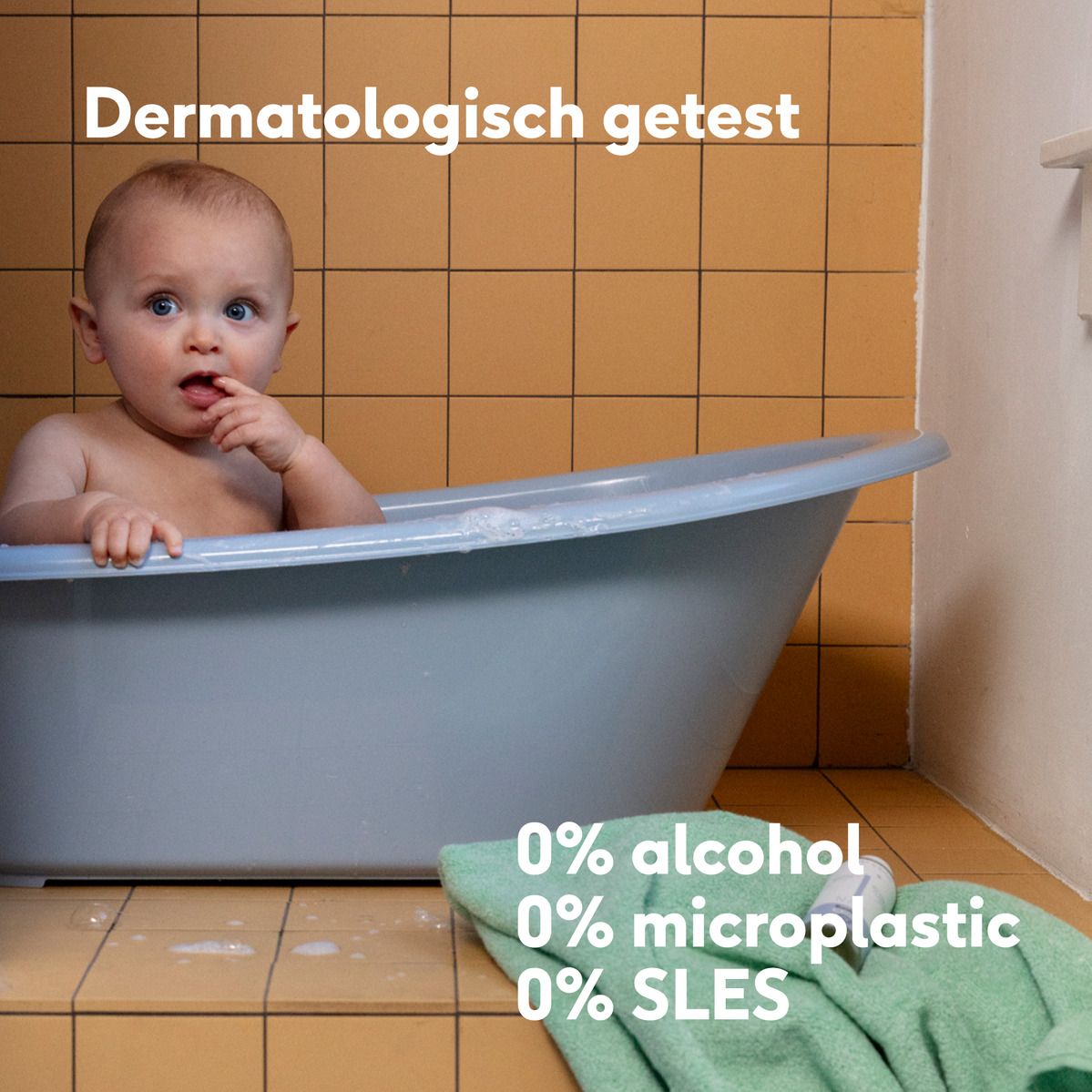 Baby in bad. Tekst: Dermatologisch getest. 0% alcohol, microplastic, SLES. Gele achtergrond.