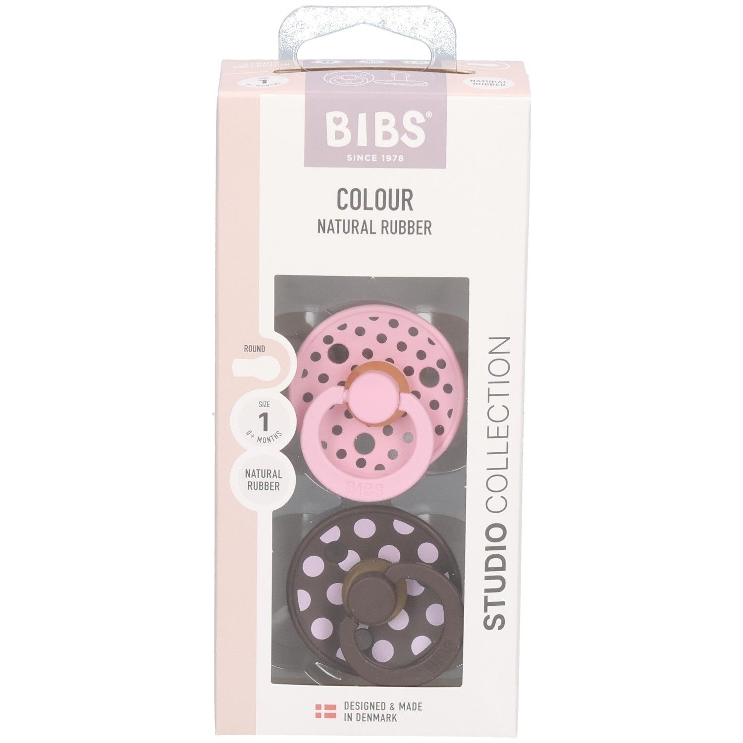 Verpakking met twee fopspenen. Roze en bruin met witte stippen. Merk: BIBS. Transparant venster.