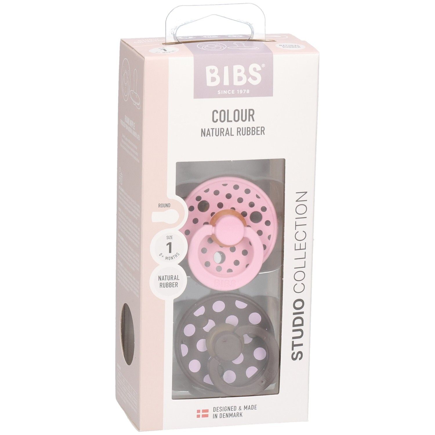 Verpakking met twee fopspenen. Roze en bruin met witte stippen. Merk: BIBS. Transparant venster.