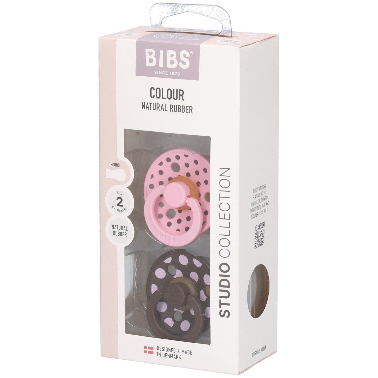 Verpakking met twee fopspenen. Roze en bruin met witte stippen. Merk: BIBS. Tekst: Colour, Natural Rubber, Studio Collection.