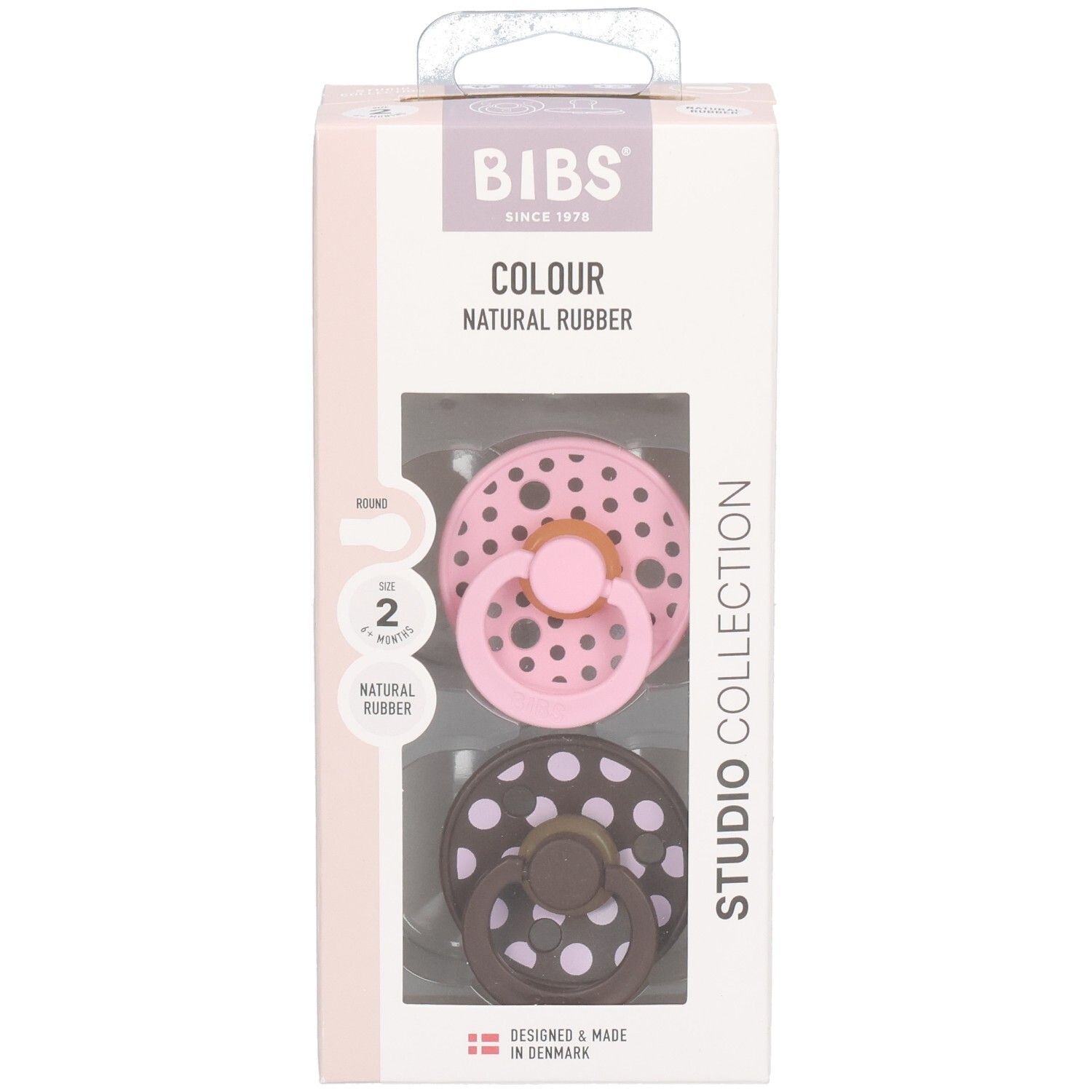 Verpakking met twee fopspenen. Roze en bruin met witte stippen. Merk: BIBS. Tekst: Colour, Natural Rubber, Studio Collection.