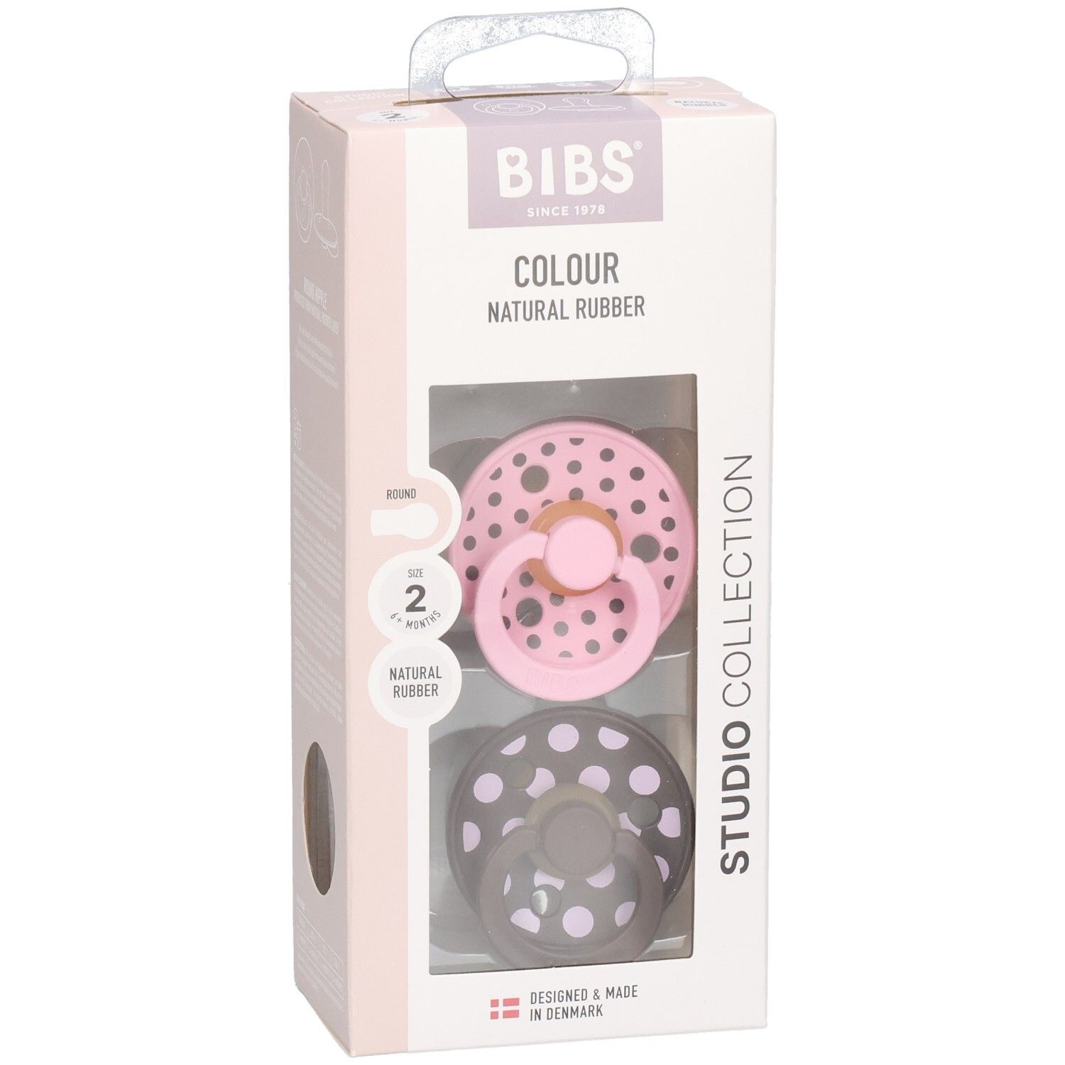 Verpakking met twee fopspenen. Roze en grijs met witte stippen. Merk: BIBS. Tekst: Colour, Natural Rubber, Studio Collection.