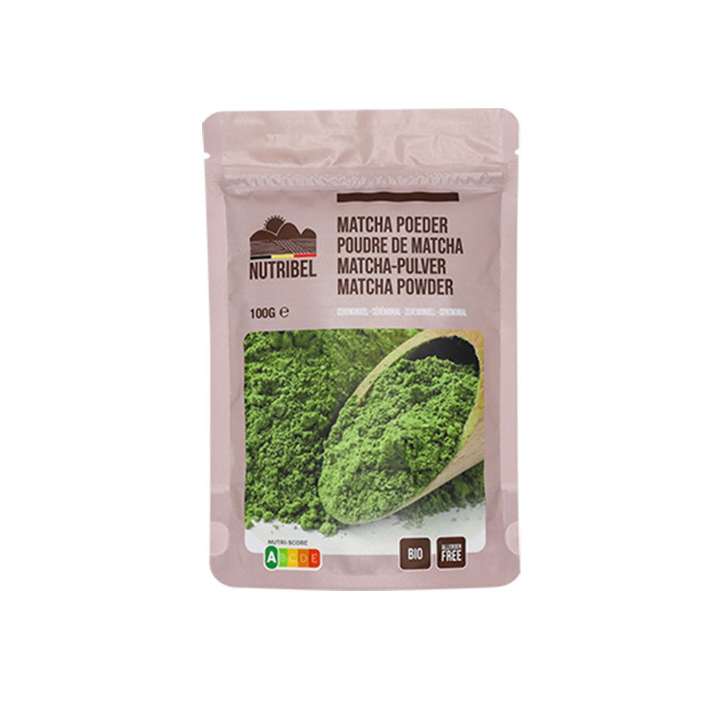 Zakje Nutribel matcha poeder. Opschrift: Matcha Poeder, 100g, Bio, glutenvrij. Groen poeder in houten lepel.