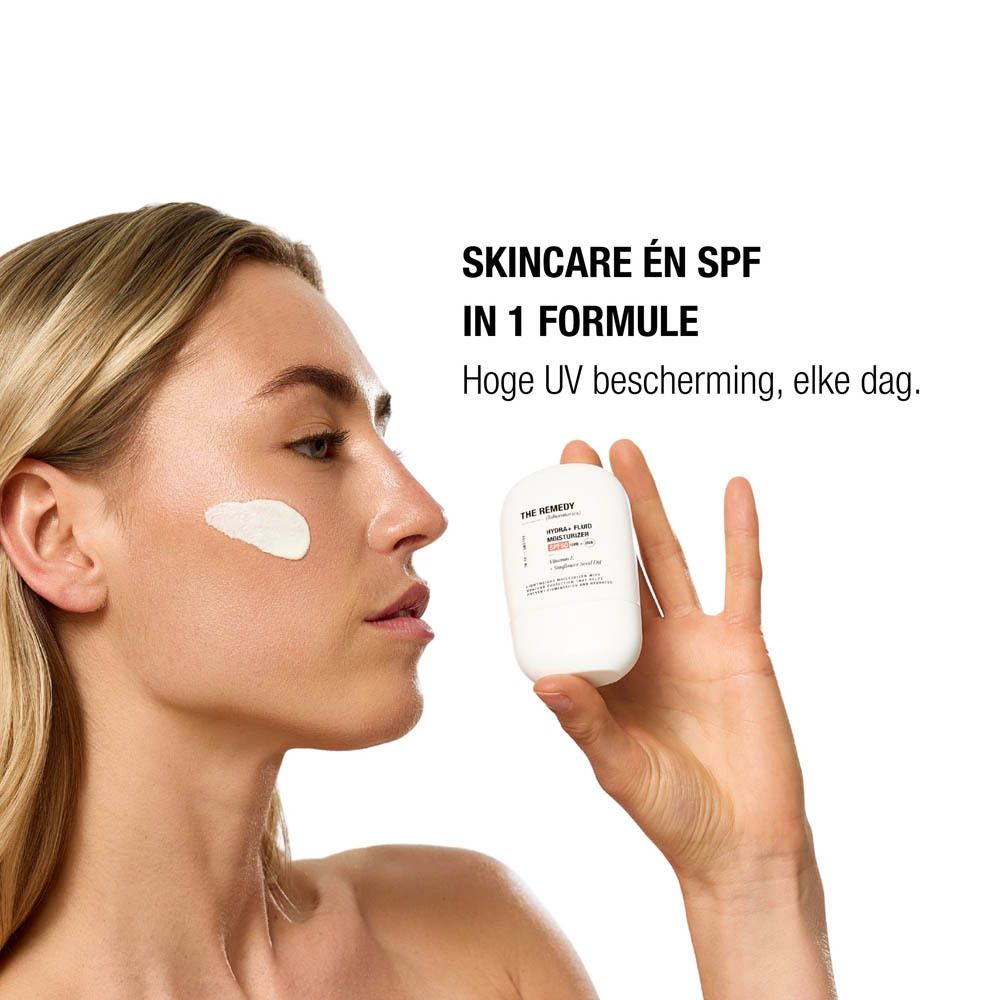 Vrouw brengt Hydra+ Fluid Moisturizer SPF50 aan, 'Skincare én SPF in 1 formule'.