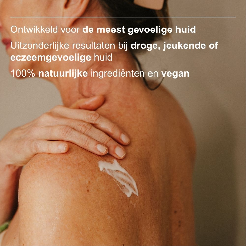 Achterkant van een witte lotionfles met pompdosering, gouden tekst over ingrediënten en zegels.
