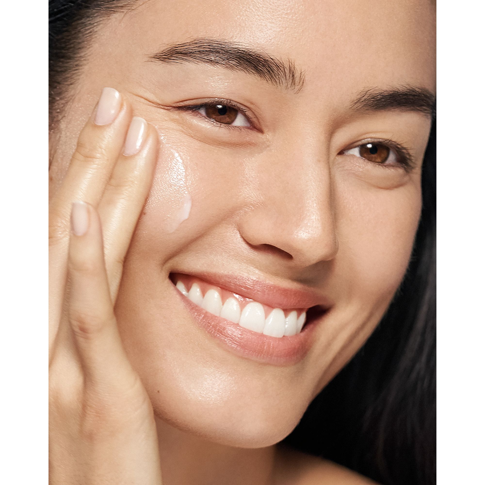 Vrouw brengt crème aan. Gezicht van een vrouw. Clinique Moisture Surge Intense 72H.