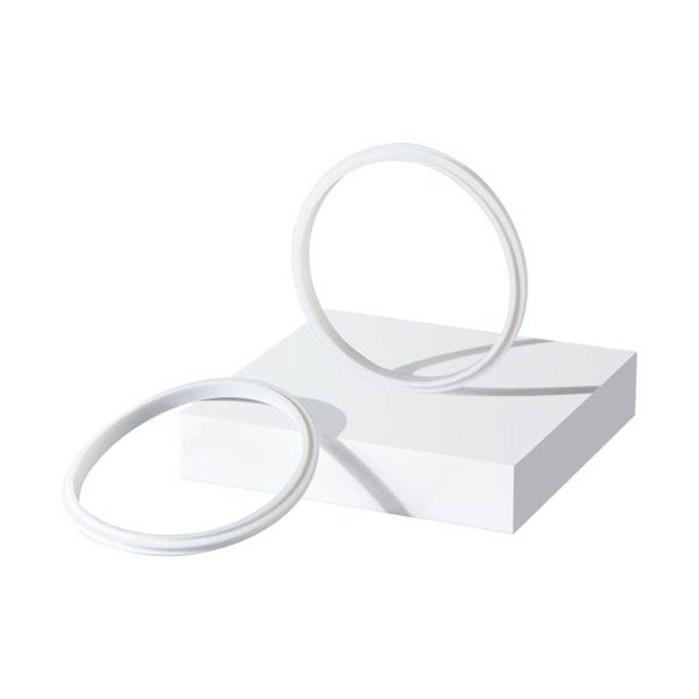Twee witte siliconen ringen liggen op een witte kubus tegen een witte achtergrond.
