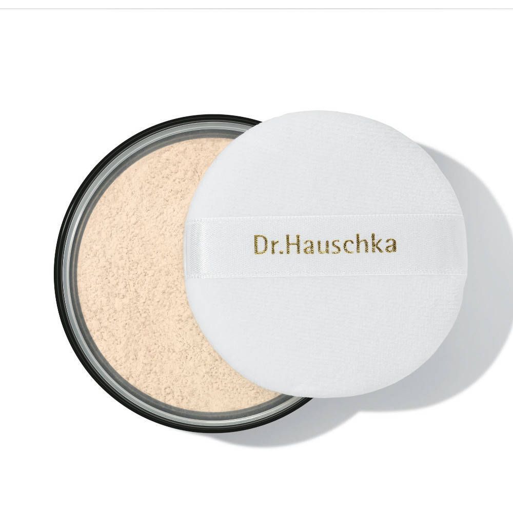 Ronde poederdoos met los poeder en een witte poederdons. Op de poederdons staat "Dr. Hauschka".