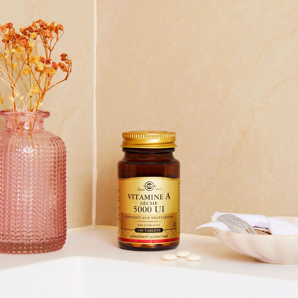 Fles op wit oppervlak. Achtergrond: vaas met bloemen, zeep.