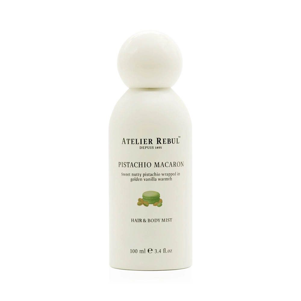 Witte fles met ronde dop. Opschrift: ATELIER REBUL, PISTACHIO MACARON, HAIR & BODY MIST. 100 ml.