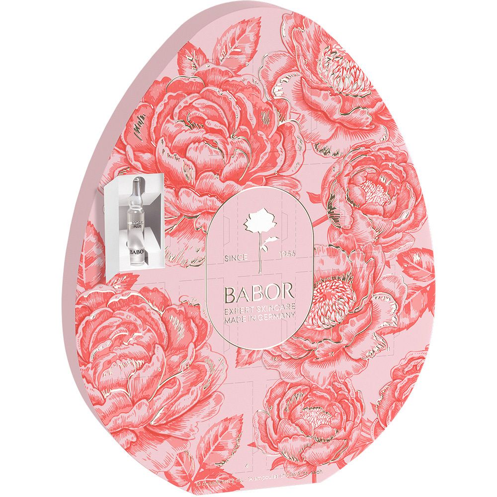 Eivormige verpakking met rozenpatroon en Babor-logo. Roze achtergrond, gouden accenten. Ampul zichtbaar.