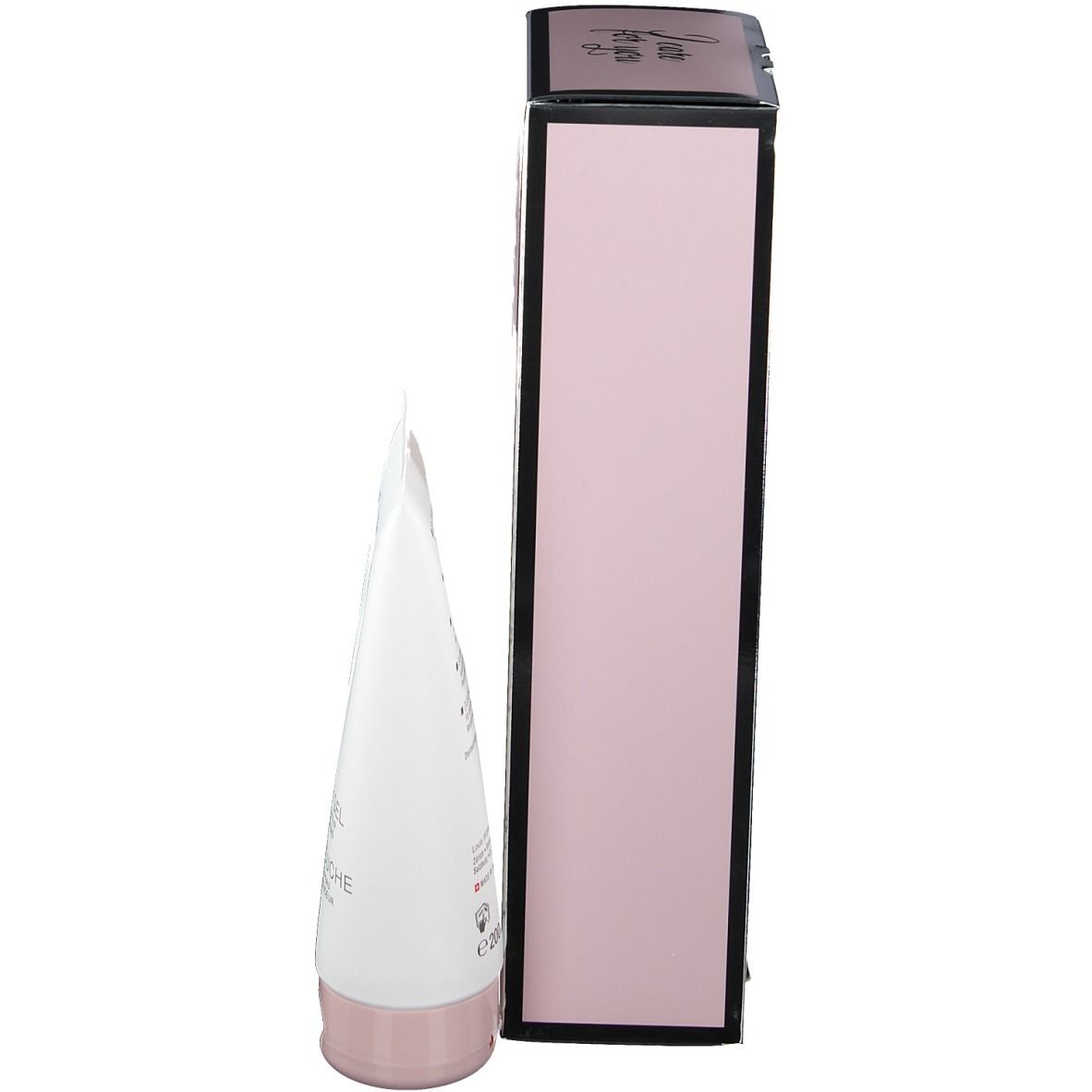 Vue latérale du coffret cadeau. Emballage rose avec cadre noir. Tube blanc avec bouchon rose. Nom du produit non visible.
