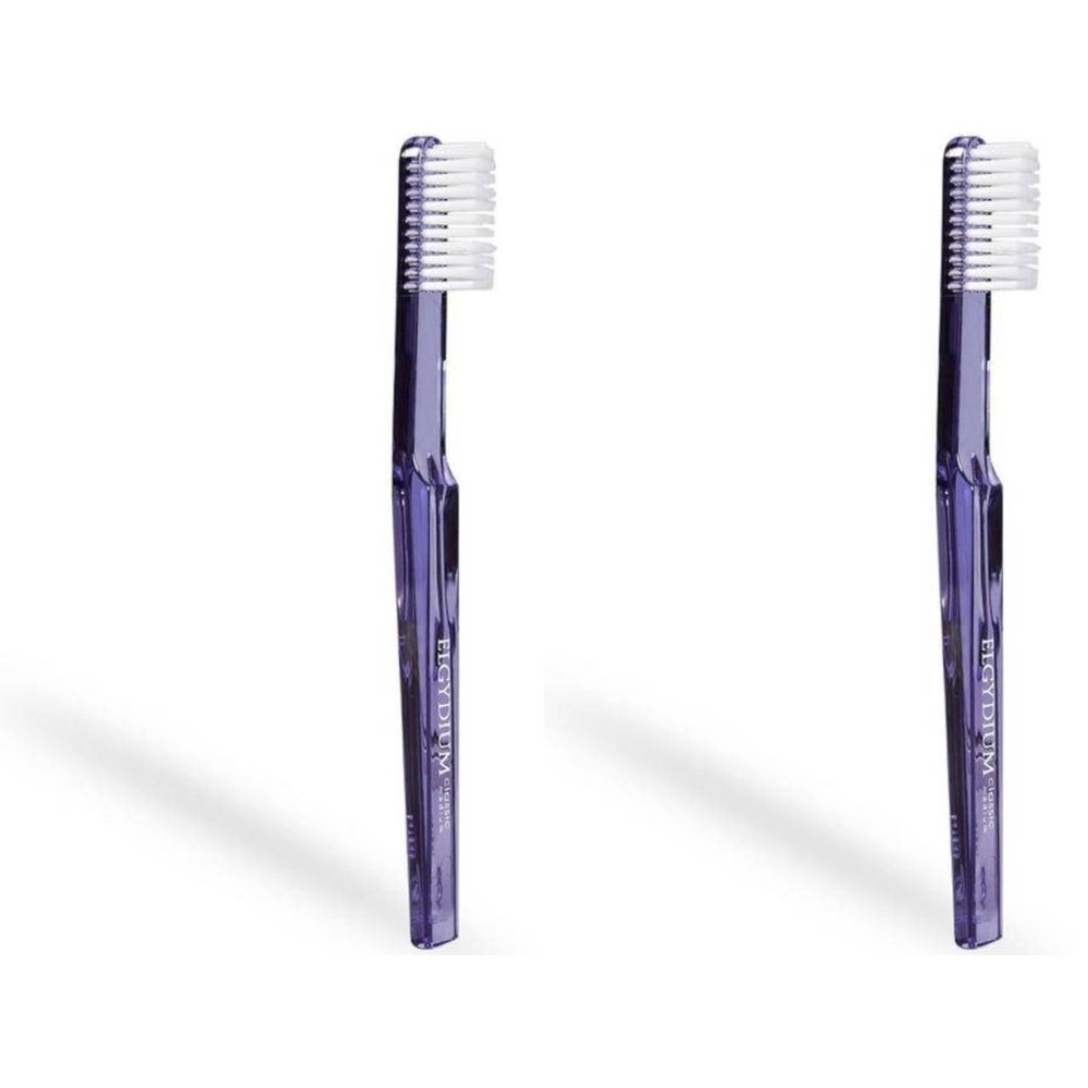 Deux brosses à dents violettes avec des poils blancs. Le manche porte l'inscription "Elgydium".