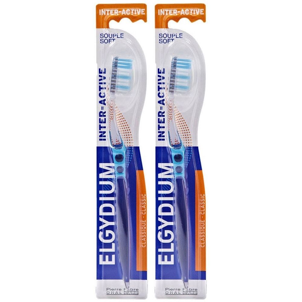 Twee tandenborstels in verpakking. Blauwe handvatten, blauwe en witte borstelharen. Opschrift: ELGYDIUM, INTER-ACTIVE, Souple Soft.