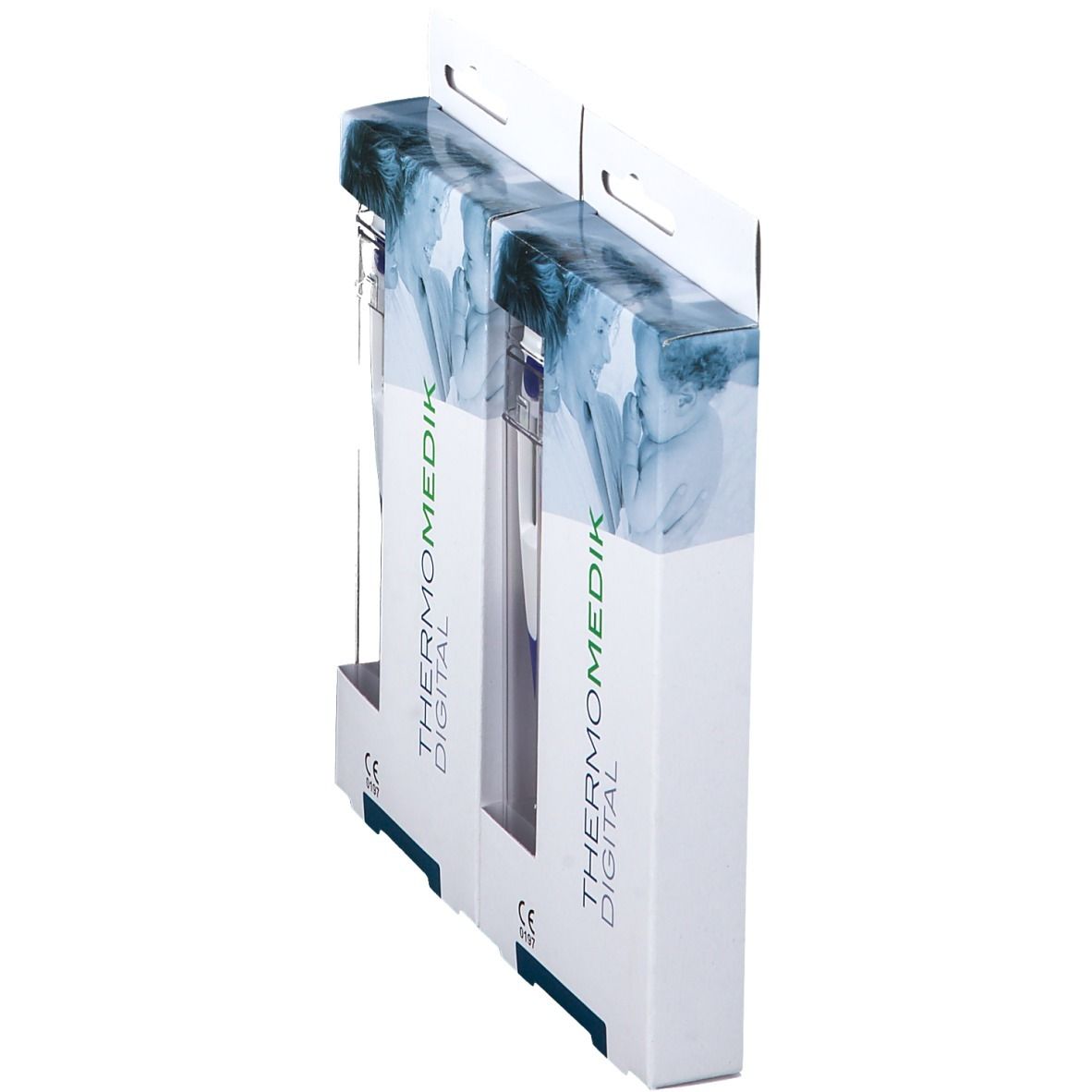 Deux emballages de thermomètres, vue latérale. Inscription: THERMOMEDIK DIGITAL. Boîtier en plastique transparent. Marquage CE.