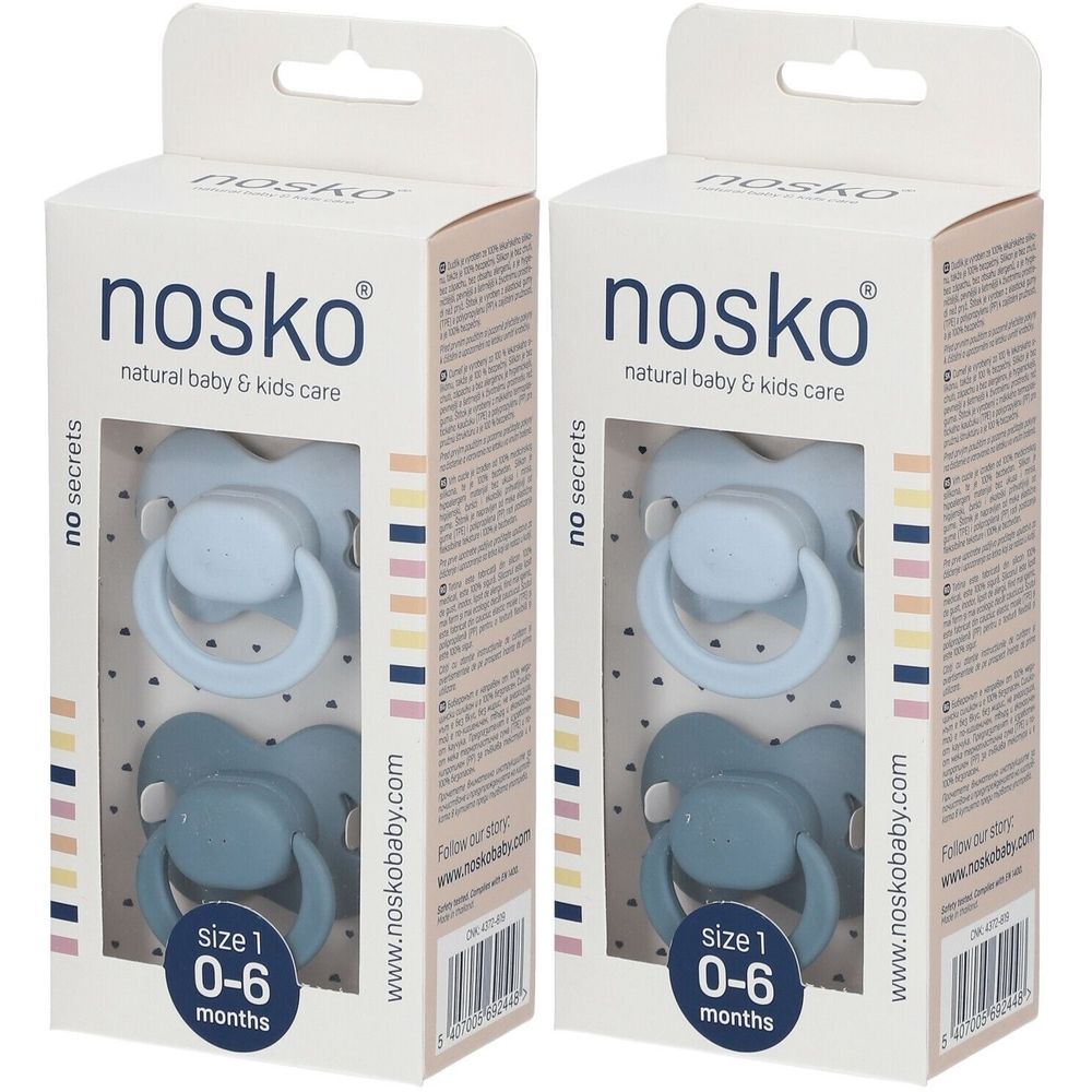 Twee blauwe fopspenen in verpakking. Merk 'nosko'. Maat 1, 0-6 maanden. Witte kartonnen verpakking met tekst en logo.