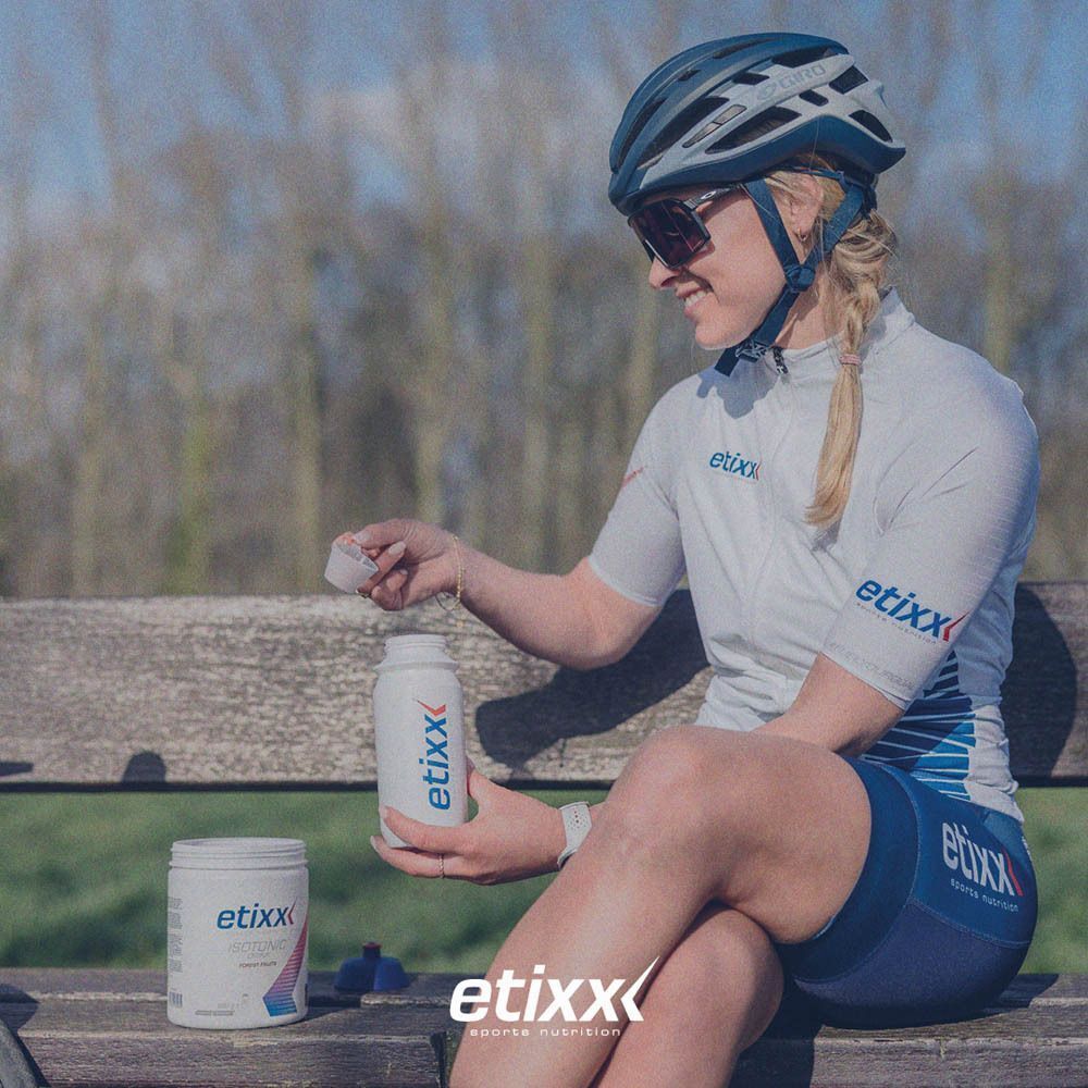 Een vrouw opent een "etixx" fles. Daarnaast een pot. Op de achtergrond een bank.