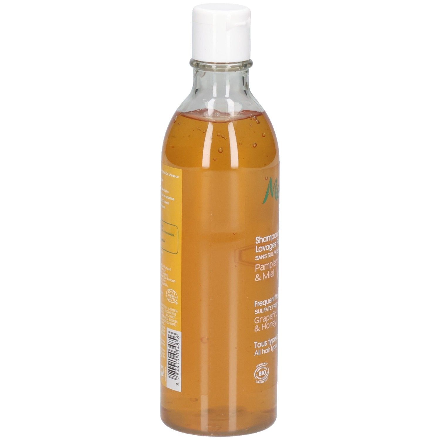 Melvita Shampoo: Grapefruit & Honing, 200ml. Zijaanzicht van de transparante fles met witte dop. Oranje vloeistof.