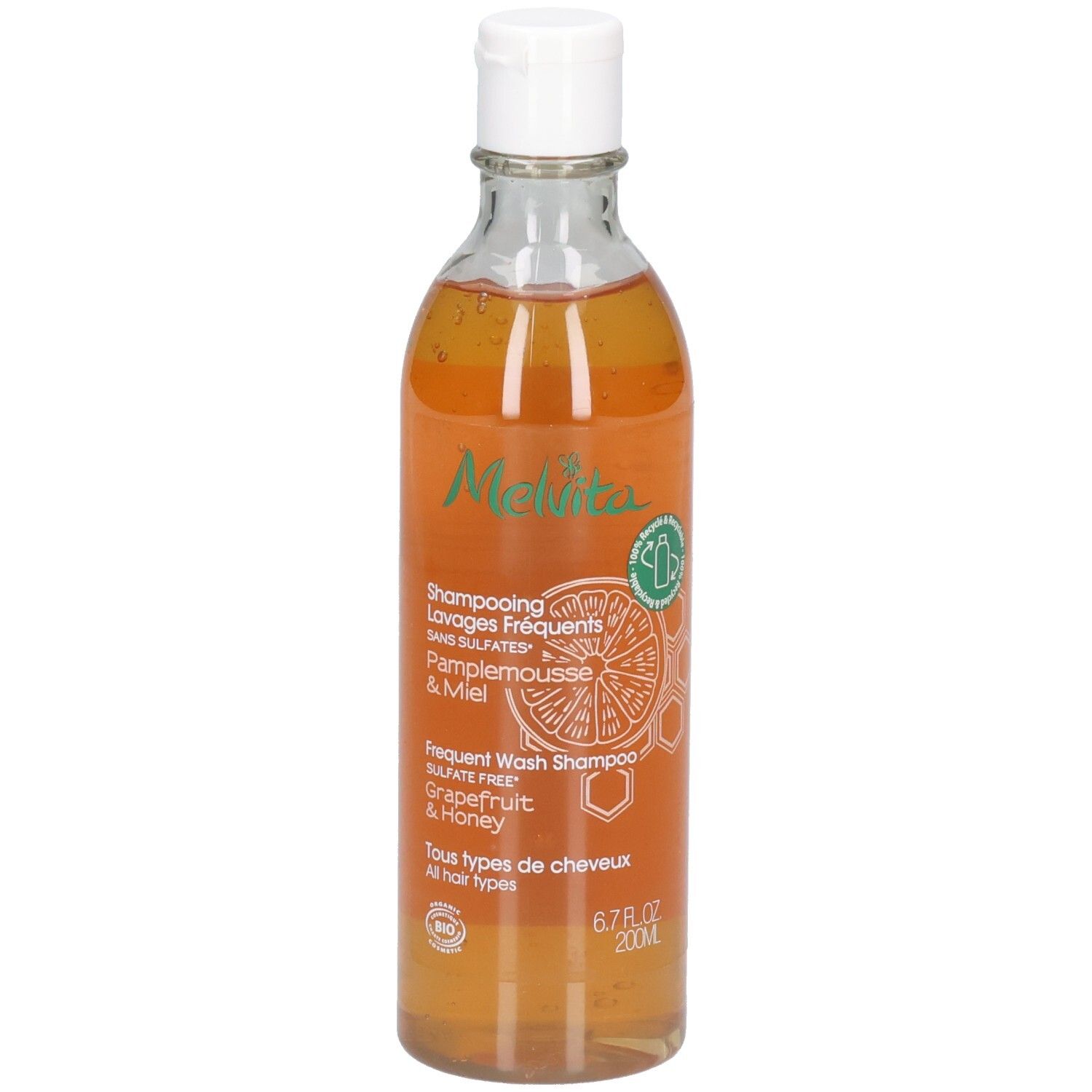 Melvita Shampoo: Grapefruit & Honing, 200ml. Transparante fles met witte dop. Oranje vloeistof.