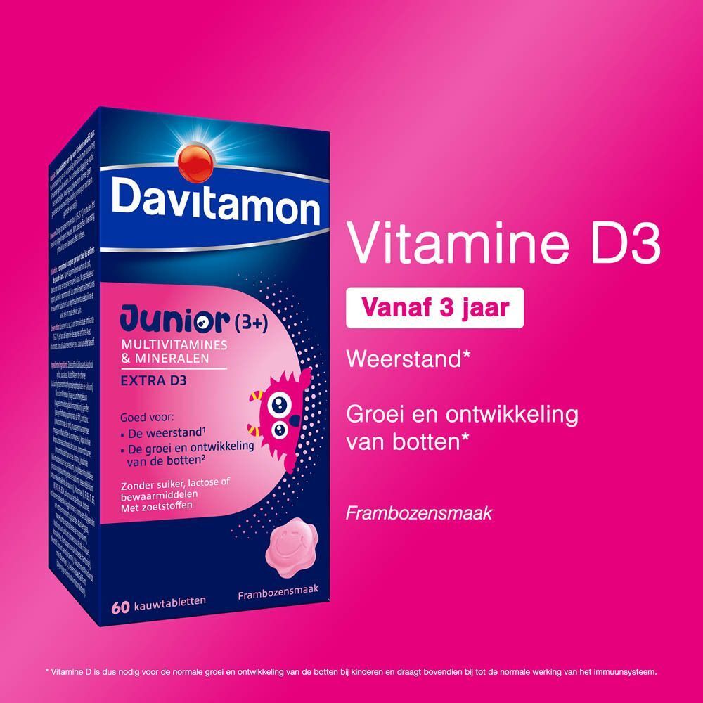 Pak Davitamon Junior Framboos Multivitaminen en Mineralen met productinformatie op roze achtergrond.