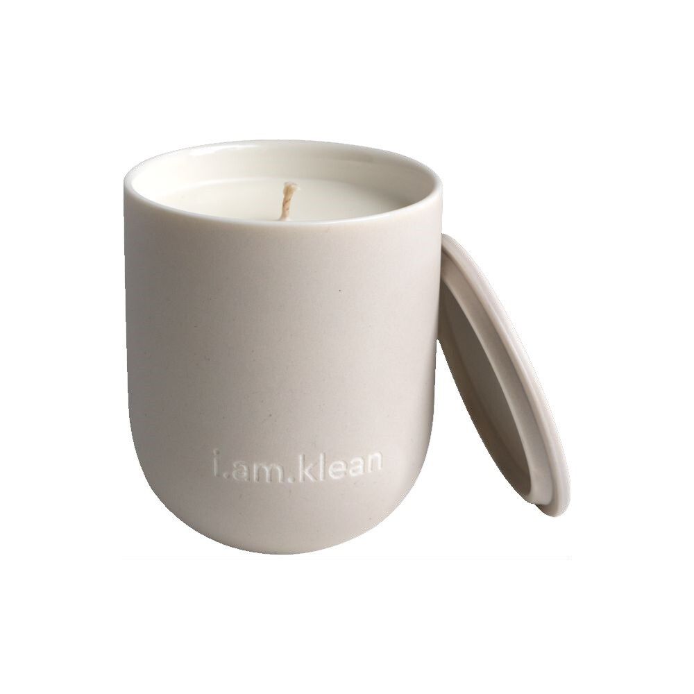 Beige keramische kaars met deksel. 'i.am.klean' staat op de voorkant. De deksel ligt ernaast.